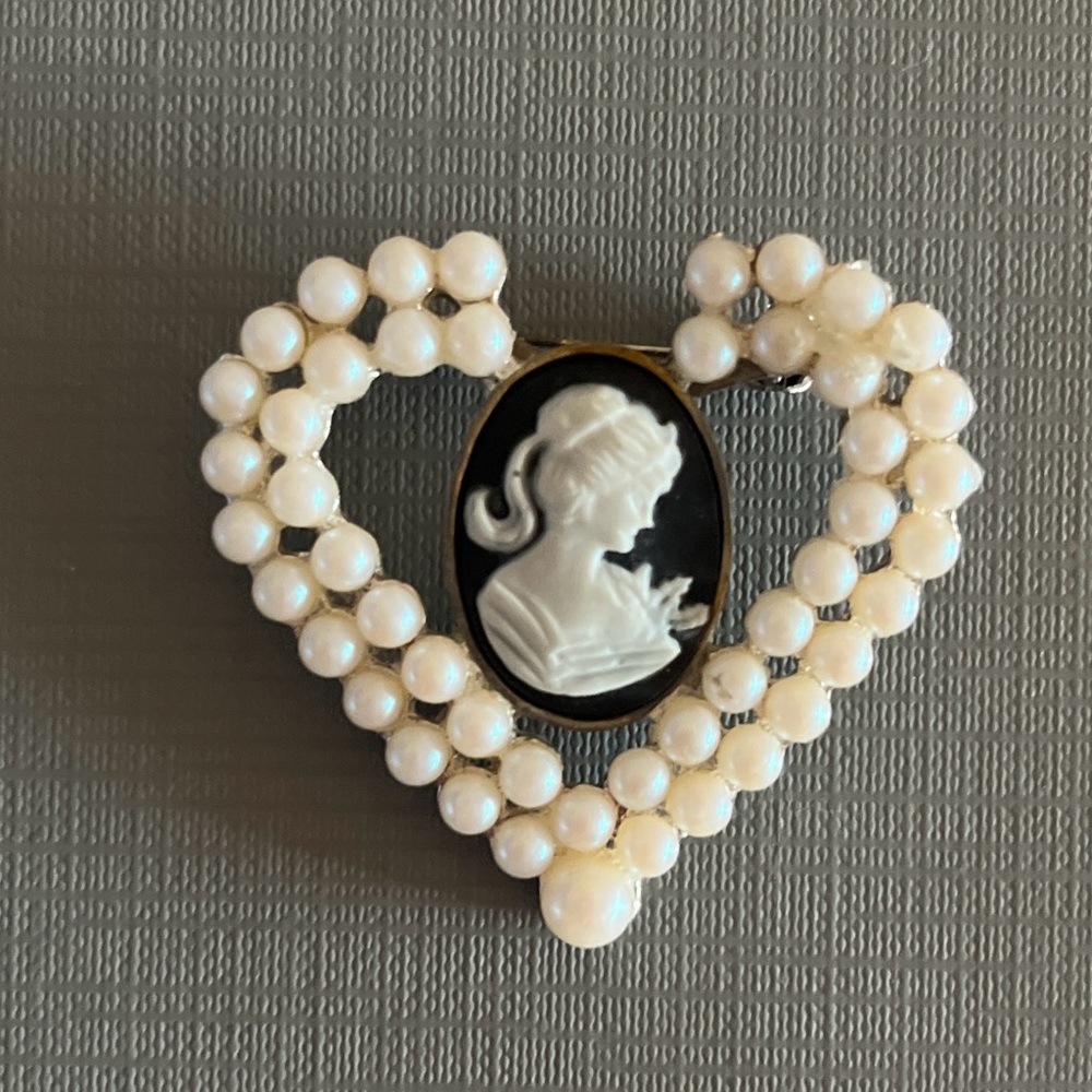 Vintage heart-shaped brooch featuring a black and white cameo with faux pearls.